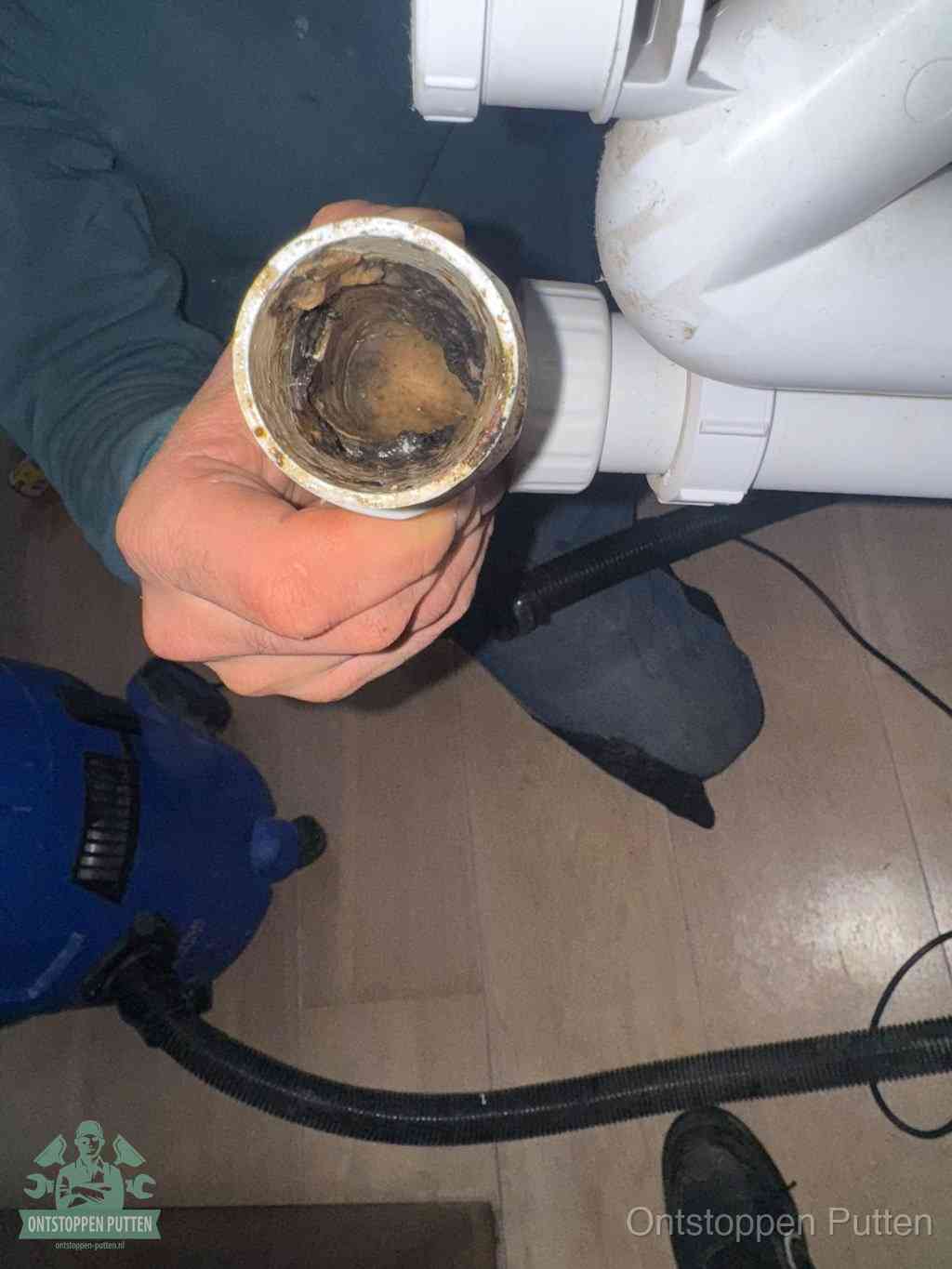 Een losgekoppeld afvoerbuisstuk dat van binnen volledig is dichtgeslibd, het gevolg van een verstopping te lang laten zitten in Putten