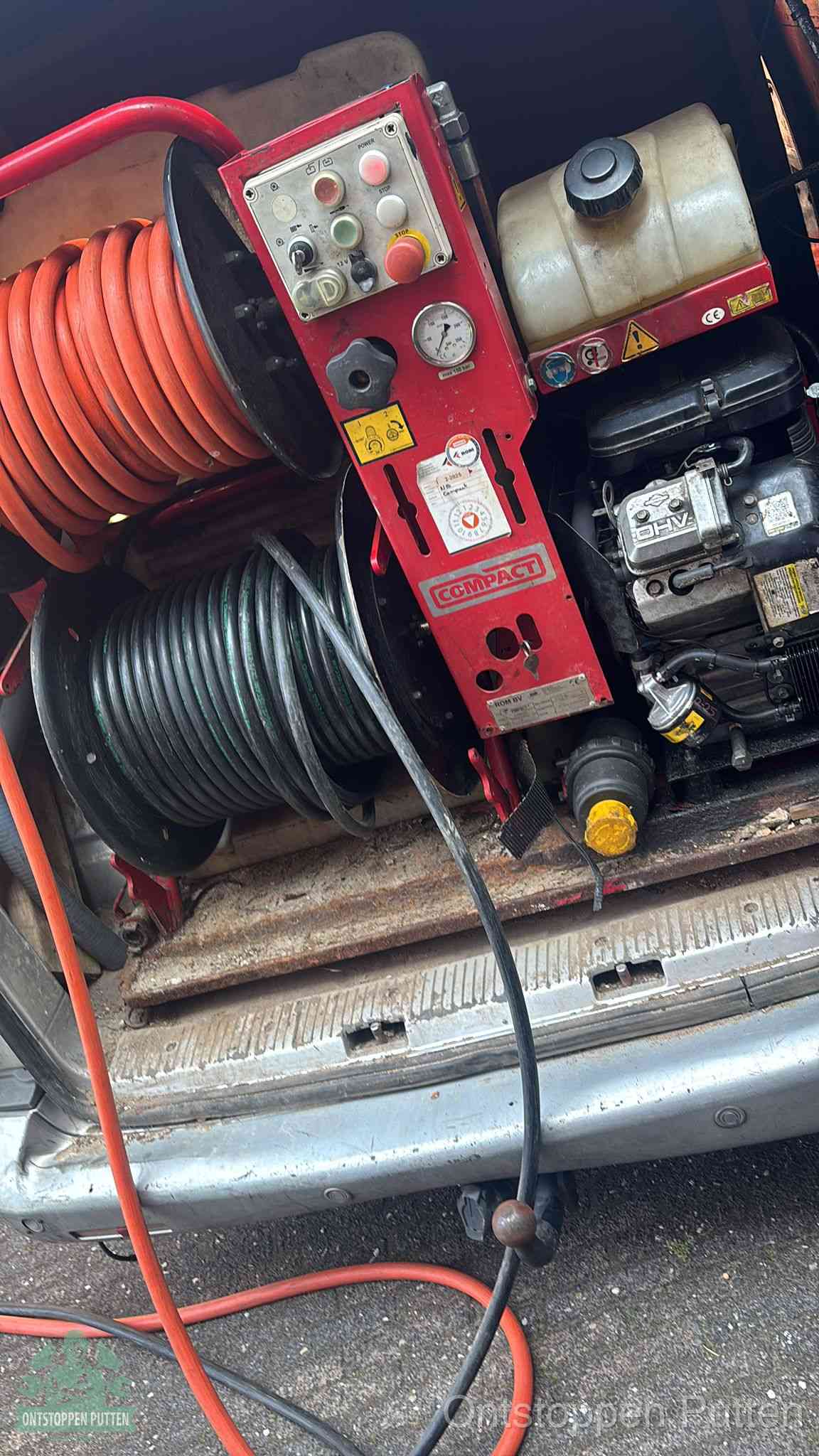 Een rood hogedruk-rioolreinigingstoestel met slangen in de laadbak van de bedrijfsbus, apparatuur voor een hardnekkige wc-verstopping in Putten