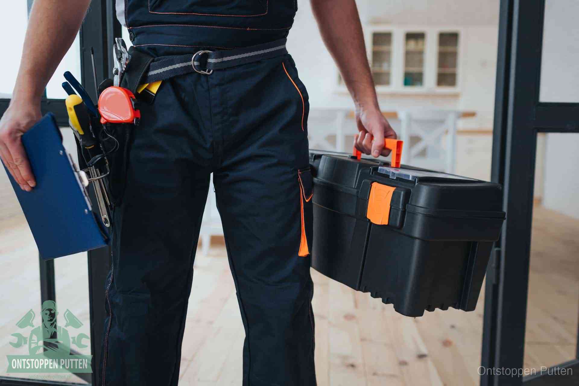 Een monteur met gereedschapsriem en klembord in een keuken, klaar om een transparante prijs voor het gootsteen ontstoppen in Putten te geven
