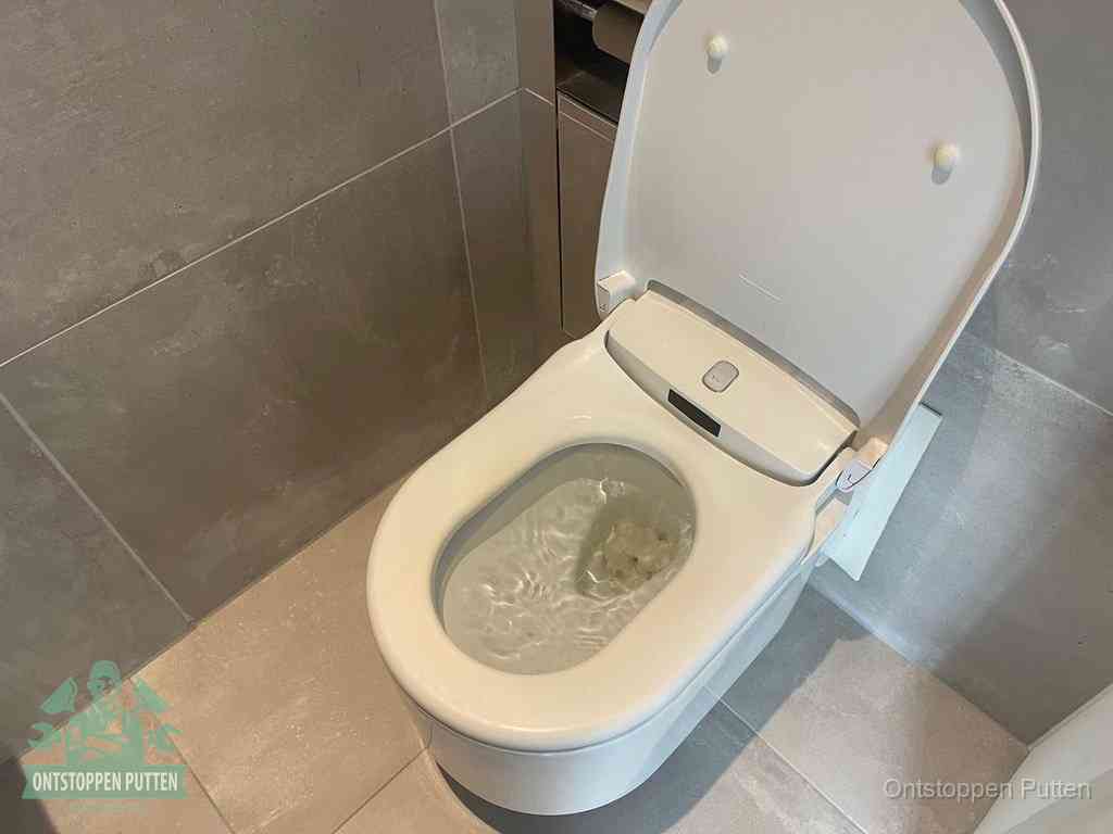 Een toiletpot vol troebel water met drijvend papier en restanten, de meest voorkomende oorzaak van een verstopte wc in Putten