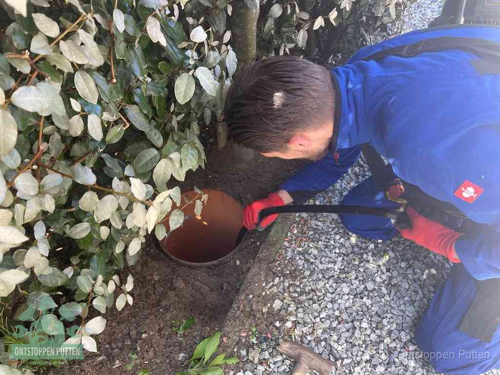 Monteur reinigt een rioolput met een slang, periodieke rioolreiniging in Putten