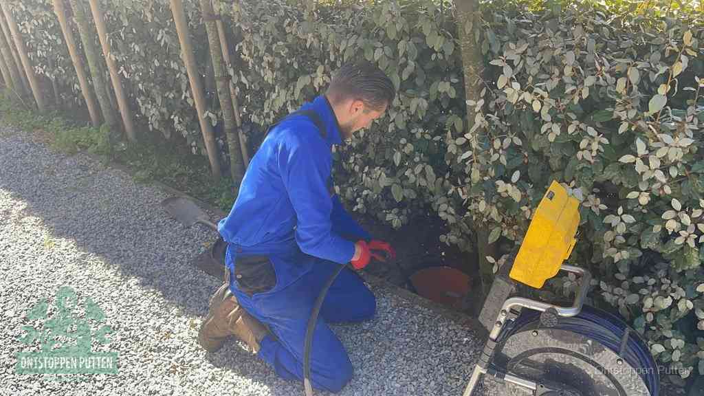 Monteur aan het werk bij een rioolput, de werkwijze voor riool ontstoppen in Putten