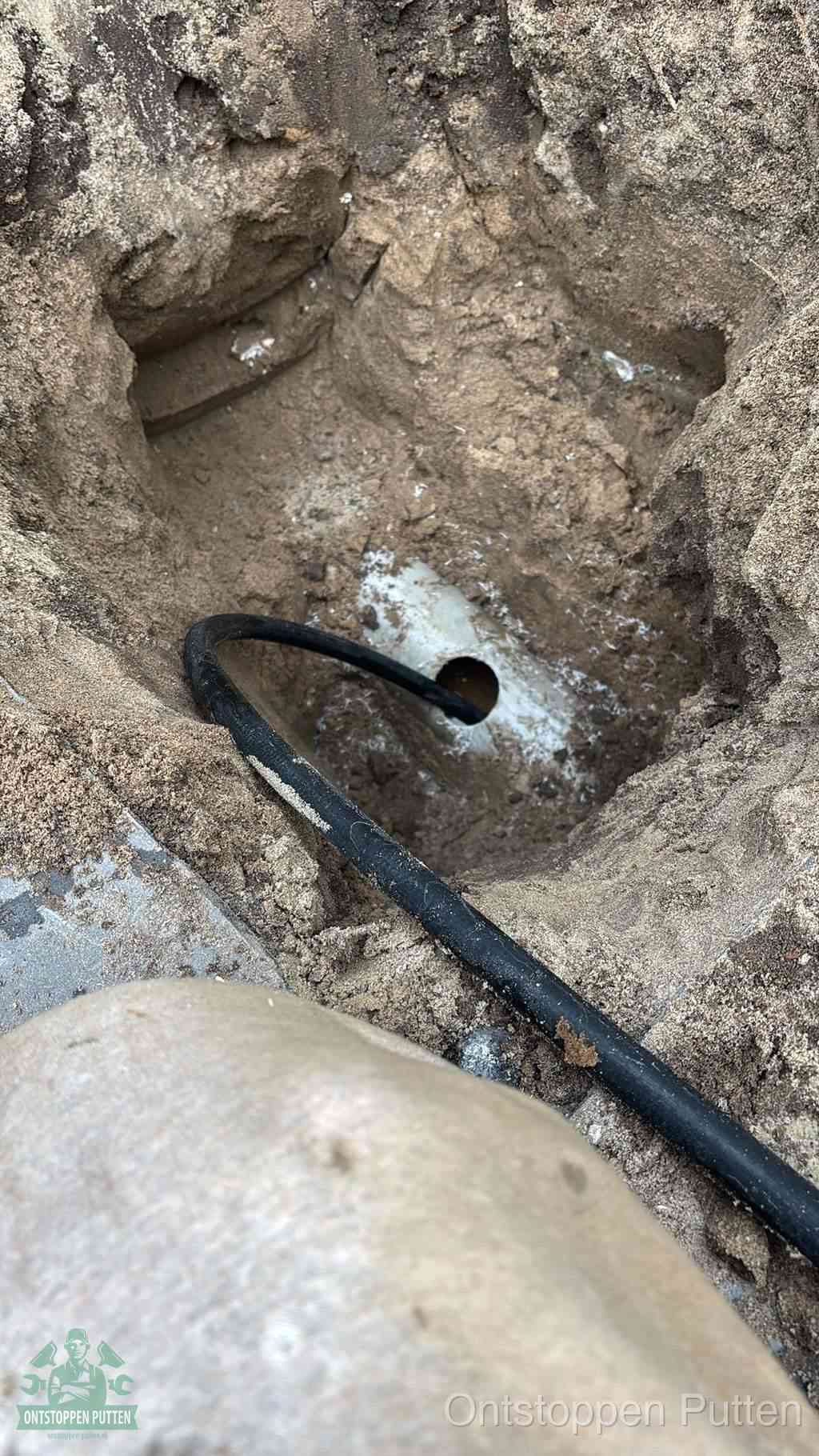 Uitgegraven rioolbuis in de grond, hulp om zelf het riool te ontstoppen in Putten